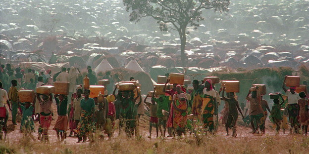 Rwandan refugees carrying water containers